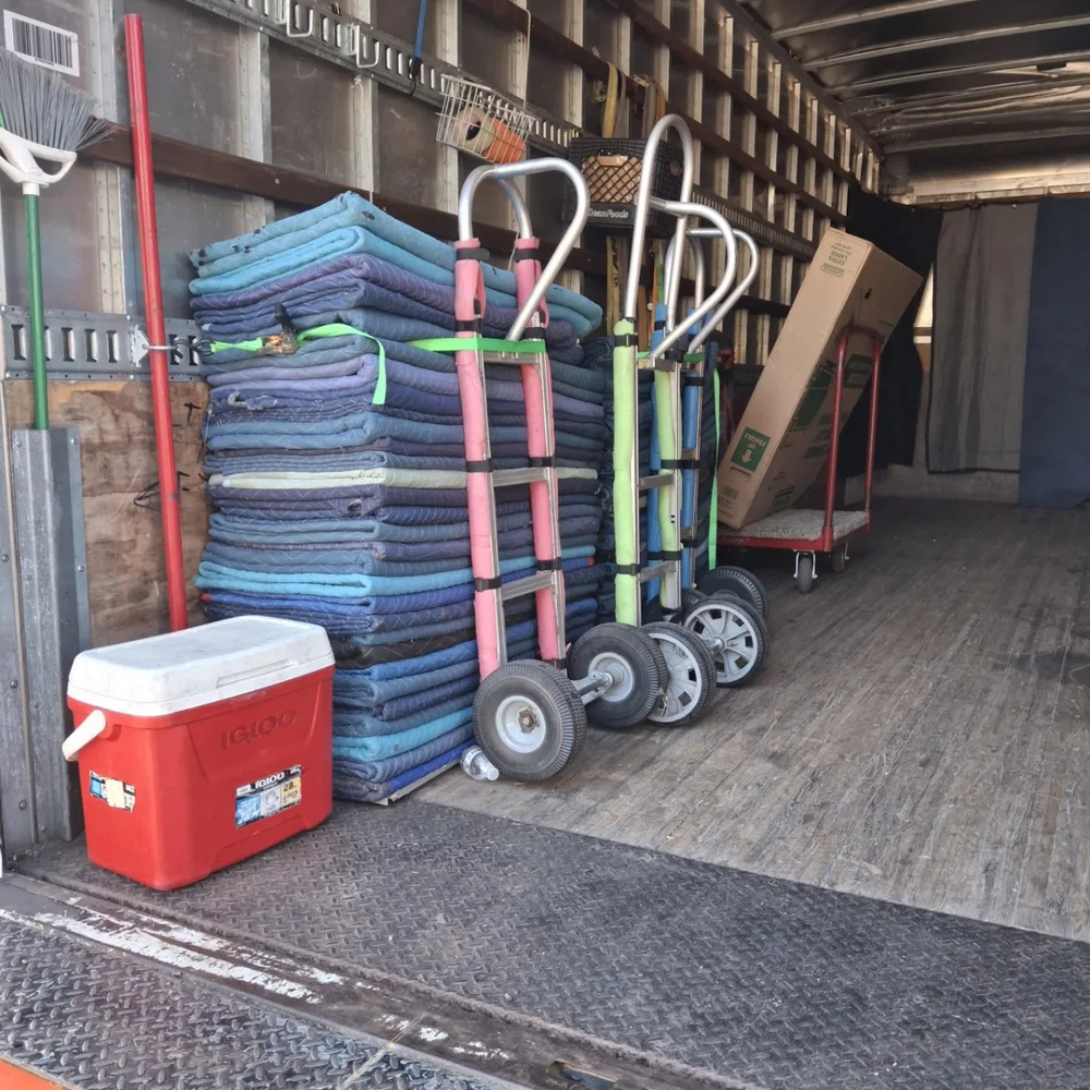 Moving blankets and dollies arranged inside a Bird Dog moving truck